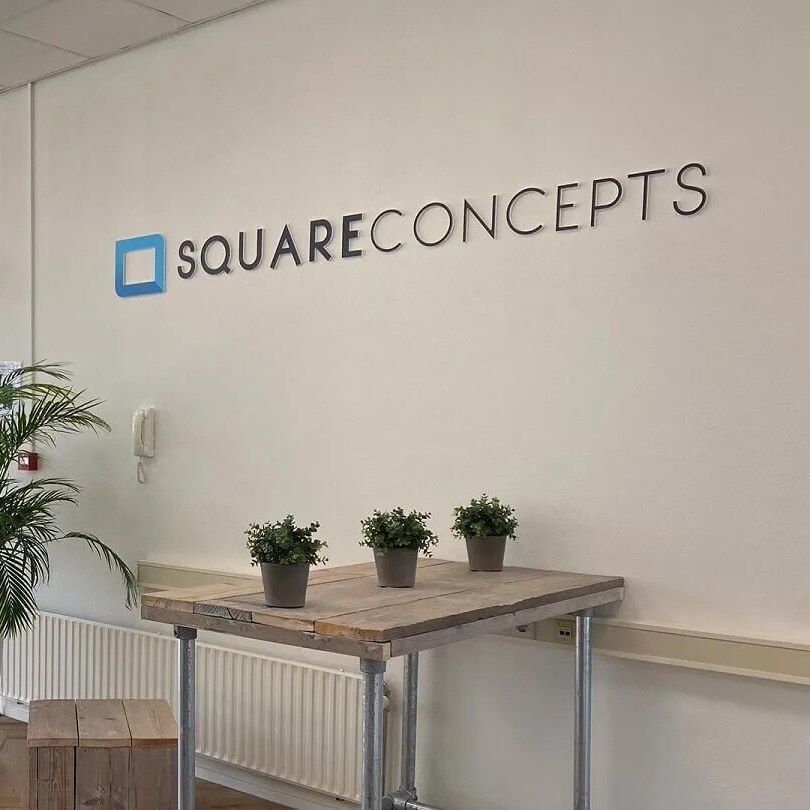 De entree van het kantoor van SQUARE Concepts in Zaltbommel, met het woordmerk op de wand.